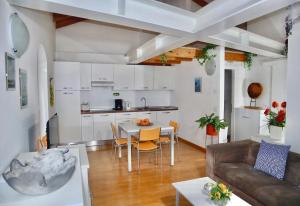 una cucina e un soggiorno con un tavolo e un divano di Windshouse Apartments a Torbole