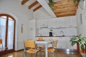 una cucina con tavolo e sedie bianchi di Windshouse Apartments a Torbole