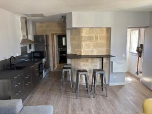 une cuisine avec un comptoir et des tabourets dans une pièce dans l'établissement New - Charming apartment - historic heart, à Montpellier 1 autre photo