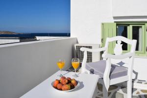 a table with a plate of fruit and two glasses of wine at Villa Isabella in Naousa