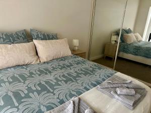 a bedroom with a bed with a blue and white blanket at The Seaview at Semaphore Park in Port Adelaide