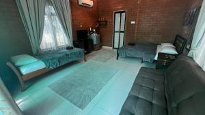 a living room with two beds and a couch at General's Lodge Staycation in Kampong Sungai Sembilang