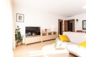 ein weißes Wohnzimmer mit einem weißen Sofa und einem TV in der Unterkunft Secrets of Montserrat in El Bruc