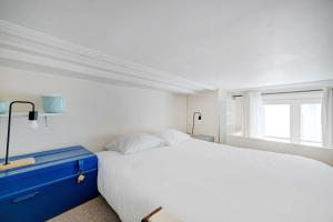 een slaapkamer met een wit bed en een raam bij Charming Studio - 2P - Sentier Montorgueil in Parijs