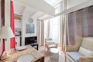 een woonkamer met een bank en een stoel bij Charming Studio - 2P - Sentier Montorgueil in Parijs