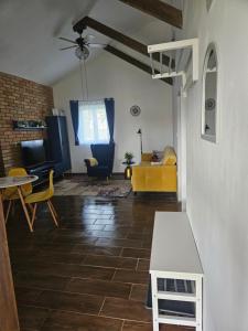 a living room with a yellow couch and a table at Marina Cottage in Enying