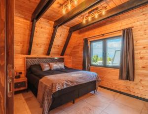 a bedroom with a bed in a log cabin at Camping Bansko "Between the Mountains" in Bansko