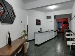 a kitchen with a counter and chairs in a room at Hotel Chalé Centro in Curvelo