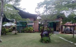 a house with a tree in front of it at General's Lodge Staycation in Kampong Sungai Sembilang