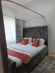 a bed with a canopy with two pillows on it at Greenstar villa homes in Kisii