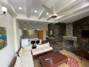 a living room with a couch and a fireplace at Mount Vista Resort in Murree