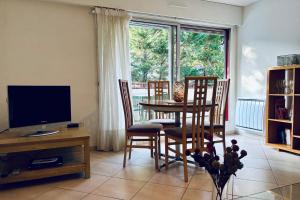 un soggiorno con tavolo, sedie e televisione di Lakeside Appartement de vacances en centre ville d'Hossegor a Hossegor