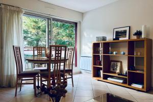 una sala da pranzo con tavolo, sedie e una finestra di Lakeside Appartement de vacances en centre ville d'Hossegor a Hossegor