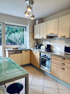 una cucina con armadi in legno e tavolo in vetro di Lakeside Appartement de vacances en centre ville d'Hossegor a Hossegor Altre 13 foto