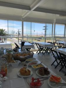 een tafel met daarop borden met eten bij Pousada Mar Alto in Ilha Comprida