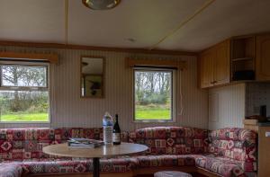 ein Wohnzimmer mit Sofas, einem Tisch und 2 Fenstern in der Unterkunft La Belle Vue in Durmignat + 12 Fotos