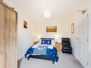 een slaapkamer met een bed en een zwarte stoel bij Harbour Retreat in Garlieston