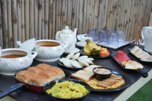 Una mesa cubierta con platos de comida y tazas de café. en Hostell One - A complete backpacker & Coworking Hub, en Pune 35 fotos más