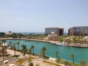 ariaal uitzicht op een rivier met palmbomen en gebouwen bij زهور المدينة in King Abdullah Economic City +16 foto's