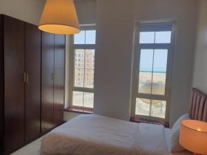 een slaapkamer met een bed en twee ramen bij زهور المدينة in King Abdullah Economic City