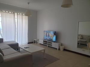 een woonkamer met een bank en een tv bij زهور المدينة in King Abdullah Economic City