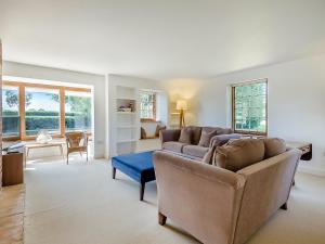 een woonkamer met een bank en een tafel bij Wittle Cottage in Quidenham