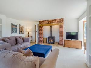 een woonkamer met een bank en een open haard bij Wittle Cottage in Quidenham