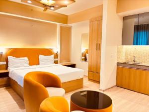 a hotel room with a bed and a chair at Hotel Four Season - Gomtinagar - Lucknow in Lucknow