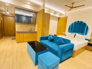 a hotel room with a bed and a blue chair at Hotel Four Season - Gomtinagar - Lucknow in Lucknow +22 photos