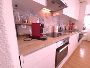 eine Küche mit einem roten Gerät auf einer Theke in der Unterkunft Caparica Escape By Gt House in Costa da Caparica