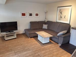 a living room with a couch and a flat screen tv at Ferienwohnung Paula in Lichtenstein