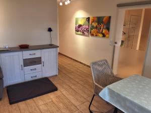 a room with a table and a cabinet and a painting at Ferienwohnung Paula in Lichtenstein