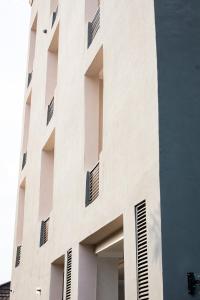 a tall white building with many windows at Nice-mason Serene and Suites in Benin City
