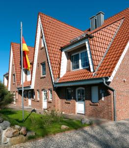 a house with a red roof and a flag at Strandglück in Insel Poel