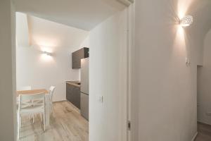 eine Küche mit weißen Wänden und einem Tisch und einem Stuhl in der Unterkunft 008 - Bright & Large Flat with AC in Perugia