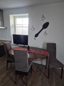 une table en bois avec des chaises et un ordinateur sur un mur dans l'établissement Haus an der Dorfteichstraße, à Alt Krenzlin