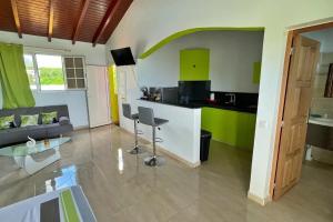 een keuken en woonkamer met een bank en een tafel bij Studio moderne près de Capesterre-Belle-Eau avec piscine in Sainte-Marie des Bois