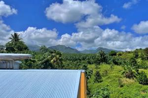 een uitzicht op de bergen vanuit een huis bij Studio moderne près de Capesterre-Belle-Eau avec piscine in Sainte-Marie des Bois