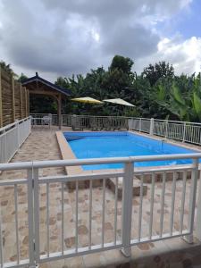 een groot zwembad met een wit hek bij Studio moderne près de Capesterre-Belle-Eau avec piscine in Sainte-Marie des Bois +7 foto's