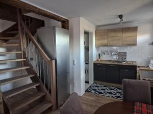 a kitchen with a stainless steel refrigerator and a staircase at Haus an der Dorfteichstraße in Alt Krenzlin