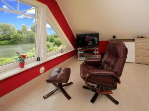 a living room with a chair and a tv at Apartment house at Kiessee, Westerholt in Westerholt