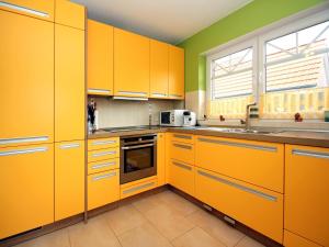 a yellow kitchen with yellow cabinets and a window at Apartment house at Kiessee, Westerholt in Westerholt +9 photos