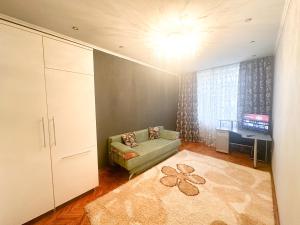 uma sala de estar com um sofá e uma televisão em Central City Puskin Street em Chişinău