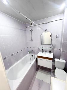 um banheiro com banheira, vaso sanitário e pia em Central City Puskin Street em Chişinău