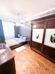 um quarto com uma cama e uma mesa em um quarto em Central City Puskin Street em Chişinău