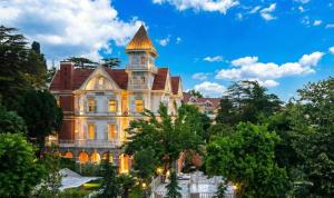 an old mansion with a tower on top of trees at Princes' Palace Resort, Buyukada - Member of The Leading Hotels of the World in Adalar