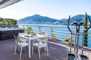 a table and chairs on a deck with a view of the water at Dukley Hotel & Resort in Budva
