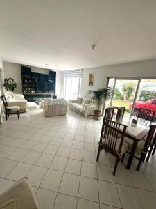 een grote woonkamer met een tafel en stoelen bij Urubamba in San Antonio