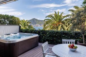 a hot tub on a deck with a table and chairs at Dukley Hotel & Resort in Budva
