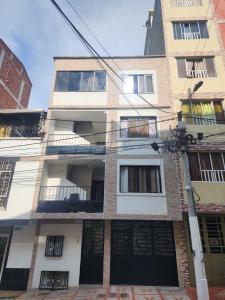 a tall building with black doors and windows at Apto a pasos del CC Delacuesta in Piedecuesta